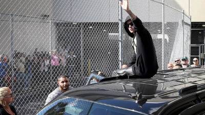 Justin Bieber saluda al público de forma irónica tras salir de prisión hoy en Miami, Estados Unidos.