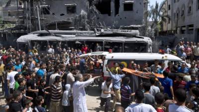 Los palestinos se reúnen alrededor de una ambulancia que transporta una de las víctimas de los bombardeos israelíes.