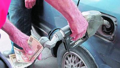 Un bombero carga combustible en un vehículo en Honduras.