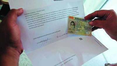 Una hondureña verifica su DNI tras reclamarla en el Registro.