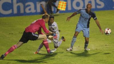 Ramiro Bruschi trata de meterse entre el arquero Kronberg y el defensa Collin.