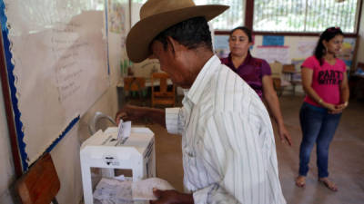 Un hondureño al momento de depositar las papeletas en las urnas tras participar en las elecciones.