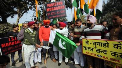 Manifestantes queman hoy domingo una bandera de Pakistán durante una protesta contra el ataque a una base de las Fuerzas Aéreas indias. EFE.