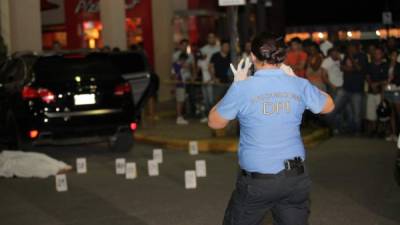 Miembros de la Dirección Policíal de Investigación toman fotos a la escena del crimen contra el futbolista Arnold Peralta.