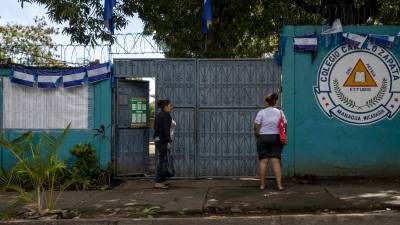 Dos mujeres hablan en la entrada del centro de votación Camilo Zapata hoy, 6 de noviembre de 2021, en Managua (Nicaragua).