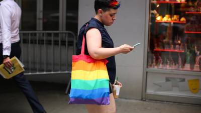 Una mujer camina con una bolsa con los colores de la comunidad LGBTI. Imagen de archivo.