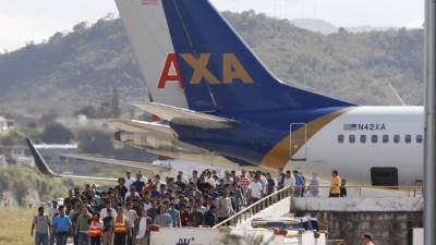 Grupo de migrantes hondureños retornados tras bajar del avión en el aeropuerto Toncontín.