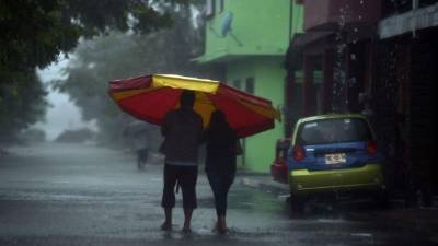 A couple walks unedr heavy rain before the arrival of hurricane Katia in Tecolutla, Veracruz state, Mexico on September 8, 2017. Hurricane Katia strengthened to category 2 on the Saffir-Simpson scale and is advancing over the Gulf of Mexico to the state of Veracruz in the east of the country, the National Water Commission (Conagua) reported. / AFP PHOTO / YURI CORTEZ