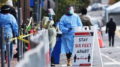 Workers in PPE are seen at the Judiciary Square Covid-19 testing site in Washington, DC, on November 18, 2020. - The United States is home to the world's largest coronavirus outbreak, with nearly 249,000 deaths as of November 18, 2020, according to Johns Hopkins University. (Photo by MANDEL NGAN / AFP)