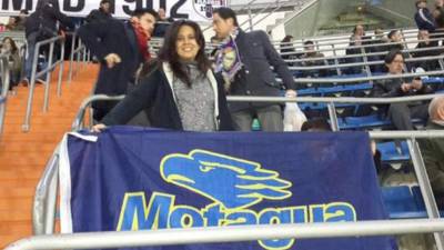La aficionada del cuadro capitalino luciendo orgullosa la bandera de su amado club en el Bernabéu. Foto Motagua Facebook.