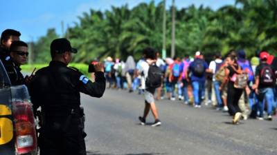 Un policía guatemalteco documento al paso de la caravana migrante por Guatemala.