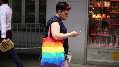 Una mujer camina con una bolsa con los colores de la comunidad LGBTI. Imagen de archivo.