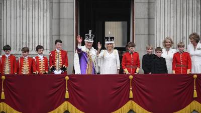 El rey Carlos III ha salido a saludar a la multitud desde el balcón del Palacio de Buckingham junto a la reina Camila y sus familias, pero sin su hijo menor Enrique, apartado de las funciones oficiales de la realeza.