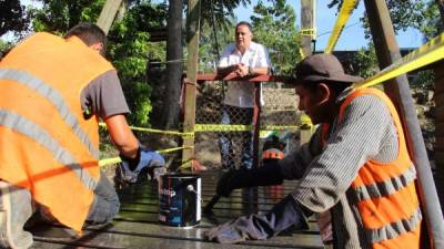 Armando Calidonio observa cuando dos trabajadores pintan la estructura.