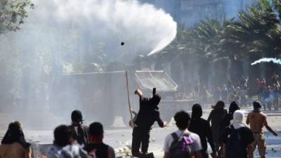Los chilenos desafían el toque de queda y se enfrentan a los militares en las calles de Santiago./AFP.