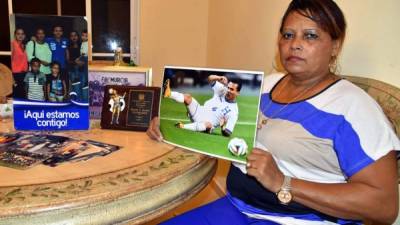 La madre del jugador, Celina Sosa, sostiene una postal del fallecido Arnold Peralta.