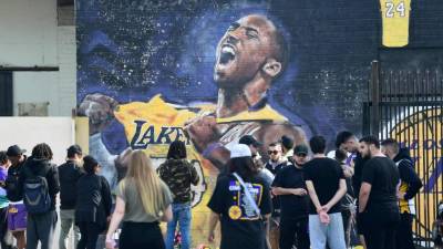 Los fanáticos se reúnen para llorar la muerte de la leyenda de la NBA Kobe Bryant en un mural cerca del Staples Center en Los Ángeles, California, el 27 de enero de 2020, un día después de que nueve personas murieron en el accidente de helicóptero que cobró la vida de la ex estrella de Los Angeles Lakers y su hija de 13 años. (Foto por Frederic J. BROWN / AFP)
