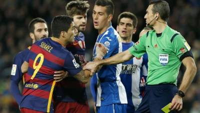 El árbitro Juan Martínez Munuera muestra la tarjeta amarilla al delantero uruguayo del FC Barcelona, Luis Suárez, durante el partido contra el Espanyol. Foto EFE
