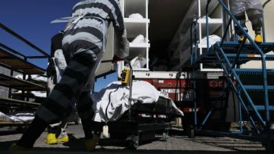 Prisioneros ayudan a trasladar los cuerpos de las víctimas de coronavirus a las morgues móviles en El Paso./AFP.