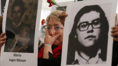La exmandataria chilena y candidata presidencial, Michelle Bachelet, fue registrada este martes al sostener una fotografía de uno de los desaparecidos de la dictadura de Augusto Pinochet, en el antiguo centro de tortura de Villa Grimaldi, en Santiago de Chile. EFE