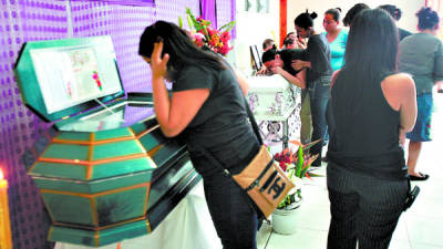 Dolientes lloran sobre los féretros de Selvin Cupertino Gómez Matamoros y su sobrino Horus Christopher Gómez Rodríguez.