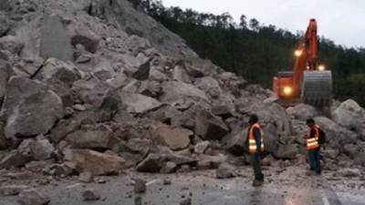 Los cuerpos de socorro trabajan para retirar los escombros de la carretera.