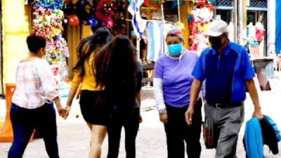 Capitalinos caminan en una calle comercial de Tegucigalpa. Foto: EFE