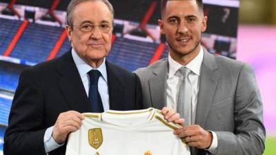 Belgian footballer Eden Hazard (R) and Real Madrid's president Florentino Perez hold the midfielder's new jersey during his official presentation as new player of the Spanish club at the Santiago Bernabeu stadium in Madrid on June 13, 2019. (Photo by GABRIEL BOUYS / AFP)