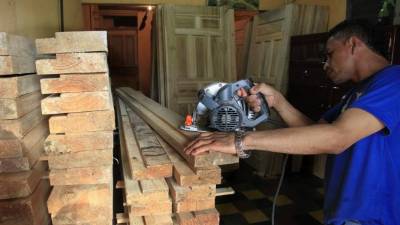 Un sampedrano trabaja en una microempresa que se dedica a la hechura de puertas de madera.