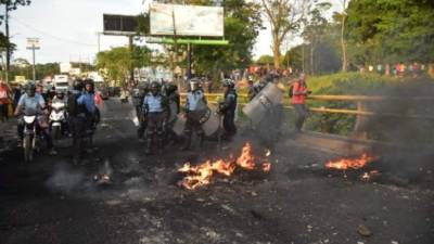 Momento en que agentes antimotines despejan la vía en La Ceiba.