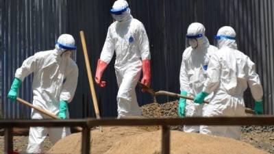 Un grupo de trabajadores sanitarios entierran desechos contaminados de ébola en las afueras de un hospital de Liberia.