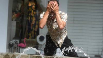 Un hombre intenta refrescarse en una fuente de Córdoba, en una jornada marcada por la ola de calor que afecta a toda la Península. EFE