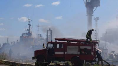 A handout photo released by the Odesa City Hall Press Office on 23 July 2022 shows firefighters working to put out a fire in a sea port of Odesa.