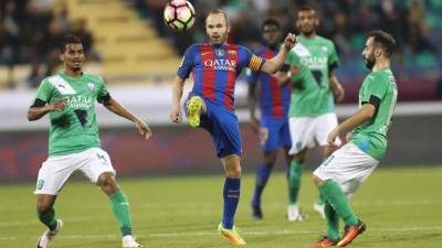 FC Barcelona's Andres Iniesta vies for the ball with Al-Ahly's Waleed Bakshween and Giannis Fetfatzidis during a friendly football match between FC Barcelona and Saudi Arabia's Al-Ahli FC on December 13, 2016 in the Qatari capital Doha.Goals from Luiz Suarez, Lionel Messi and Neymar helped Barcelona beat Saudi champions Al-Ahli 5-3 in a thrilling friendly in Doha. The superstar trio all scored by the 17th minute, helping the Spanish giants to stroll into an early three-goal lead. / AFP PHOTO / KARIM JAAFAR