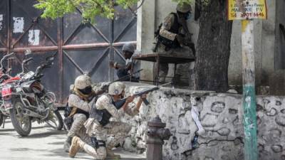 Police exchange fire with armed men next to the Petionville police station in Port-au-Prince on July 8, 2021. - Police in Haiti have surrounded a group of possible suspects in the assassination of President Jovenel Moise, the UN envoy to Haiti said. Helen La Lime said from the Haitian capital that four members of a group that attacked the presidential palace Wednesday and shot the president have been killed by police and six others are in custody. (Photo by Valerie Baeriswyl / AFP)