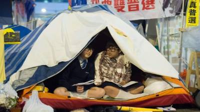 Dos jovenes activistas se entretienen en el campamento pro democracia