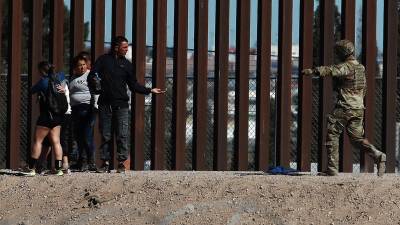 Integrantes de la Guardia Nacional de Estados Unidos impide el avance de migrantes que intentan cruzar la frontera con México.