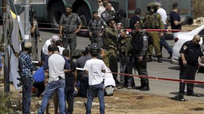 Colonos israelíes y soldados rodean a un palestino herido tras un ataque contra un policía . EFE