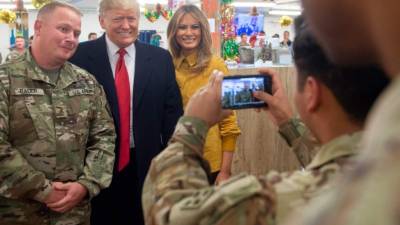 El presidente de EEUU Donald Trump posa junto a su esposa Melania y miembros de las tropas estadounidenses en Irak. Foto: AFP