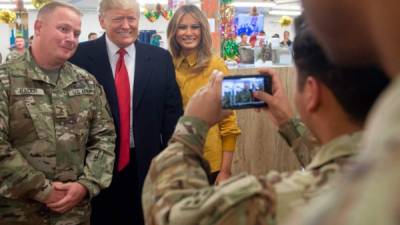 El presidente de EEUU Donald Trump posa junto a su esposa Melania y miembros de las tropas estadounidenses en Irak. Foto: AFP