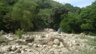 Las aguas de la Quebrada Sorosca arrastraron a dos primos ante la crecida por las torrenciales lluvias en San Juan de Opoa en el occidente de Honduras.