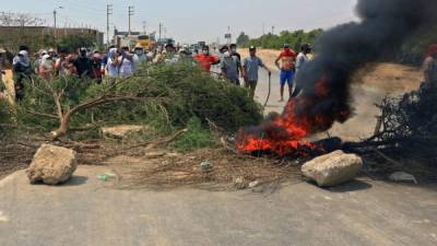 En una escena que recuerda la forma en que se protesta en Honduras, los trabajadores peruanos bloquearon las carreteras con palos, piedras y llantas en llamas, cerca de la localidad de Viru.