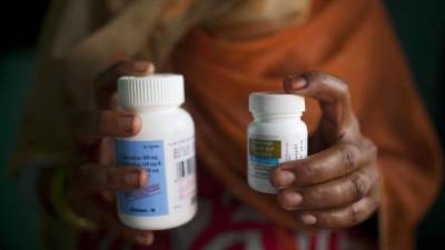 Una mujer india infectada por el virus VIH muestra los antiretrovirales que le ayudan a mitigar los efectos de la enfermedad.