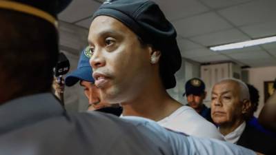 El exinternacional brasileño Ronaldinho Gáucho sale del despacho de la jueza de turno de Penal de Garantías, Clara Ruiz Díaz, este sábado, en Asunción (Paraguay). EFE/ Nathalia Aguilar