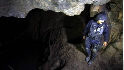 Un policía federal muestra una la cueva donde permanecía escondido 'la Tuta' en Morelia.