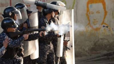 Riot police clash with anti-government demonstrators in the neighborhood of Los Mecedores, in Caracas, on January 21, 2019. - A group of soldiers rose up against Venezuela's President Nicolas Maduro at a command post in northern Caracas on Monday, but were quickly arrested after posting an appeal for public support in a video, the government said. (Photo by Federico Parra / AFP)