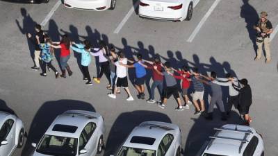 Un grupo de estudiantes es evacuado de la secundaria Marjory Stoneman Douglas, escenario de la masacre de Parkland, Florida, en una foto de archivo tomada el 14 de febrero de 2018.