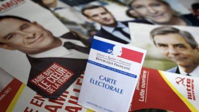 Una credencial para votar es fotografiada sobre los panfletos de los once candidatos para las presidenciales francesas en París (Francia) ayer, 21 de abril de 2017. EFE