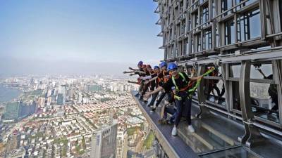 Police officers and others stand during a three-minute national memorial to commemorate those who died in the COVID-19 coronavirus outbreak, in Wuhan in China's central Hubei province on April 4, 2020. - China came to a standstill on April 4 to mourn patients and medical staff killed by the coronavirus, as the world's most populous country observed a nationwide three-minute silence. (Photo by STR / AFP) / China OUT
