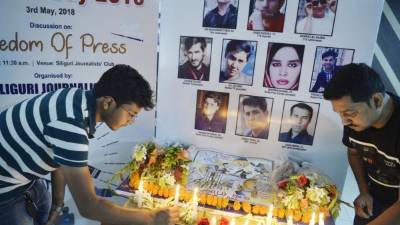 Indian journalists light candles during a vigil for ten Afghan journalists who were killed in a targeted suicide bombing during an event to mark World Press Freedom Day in Siliguri on May 3, 2018. Ten journalists were killed April 30, including Agence France-Presse chief photographer Shah Marai, in attacks in Kabul that sparked outrage around the world and underscored the dangers faced by Afghan media. / AFP PHOTO / DIPTENDU DUTTA